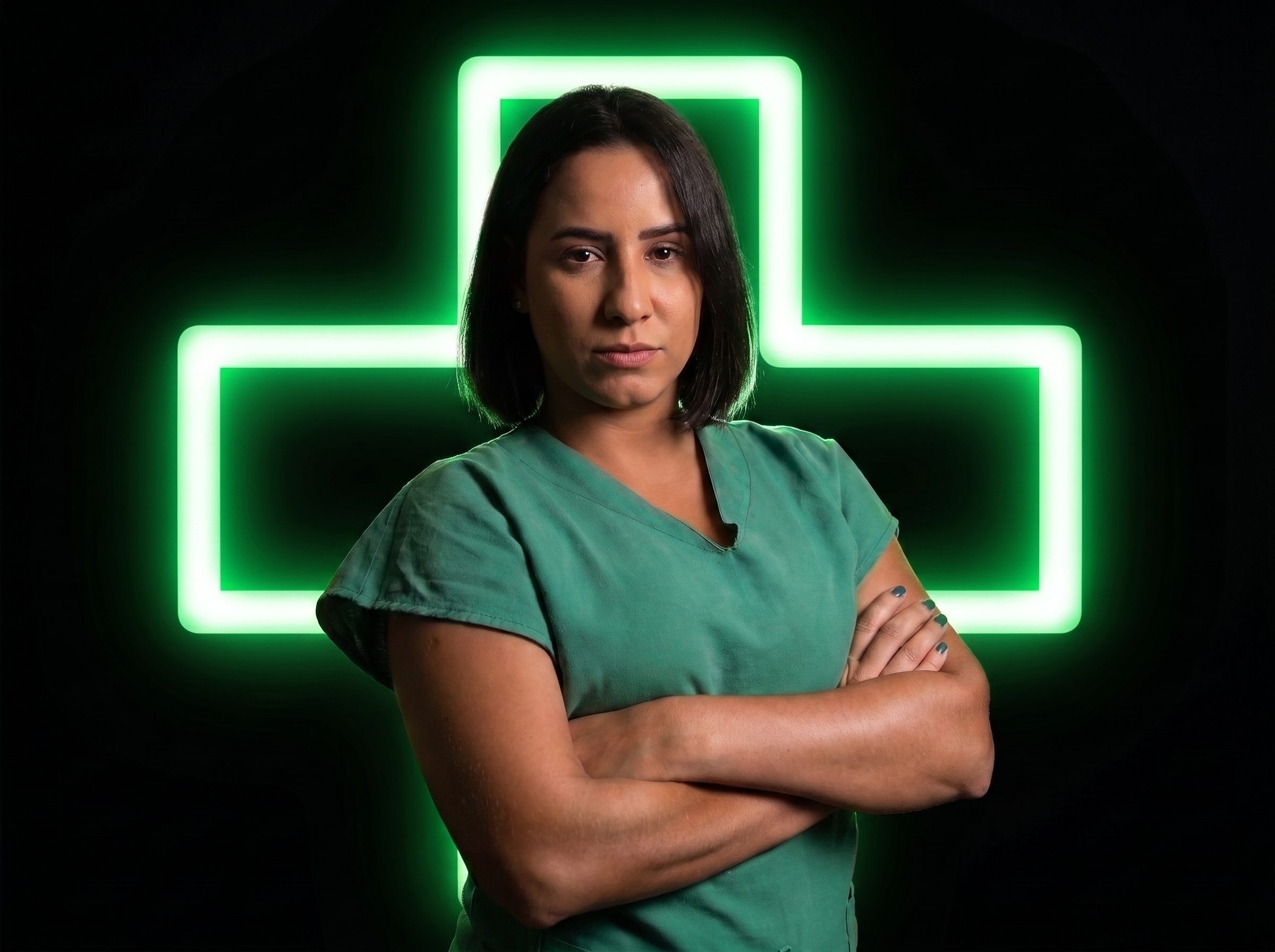 Camila Cardoso de braços cruzados diante de uma cruz de neon verde