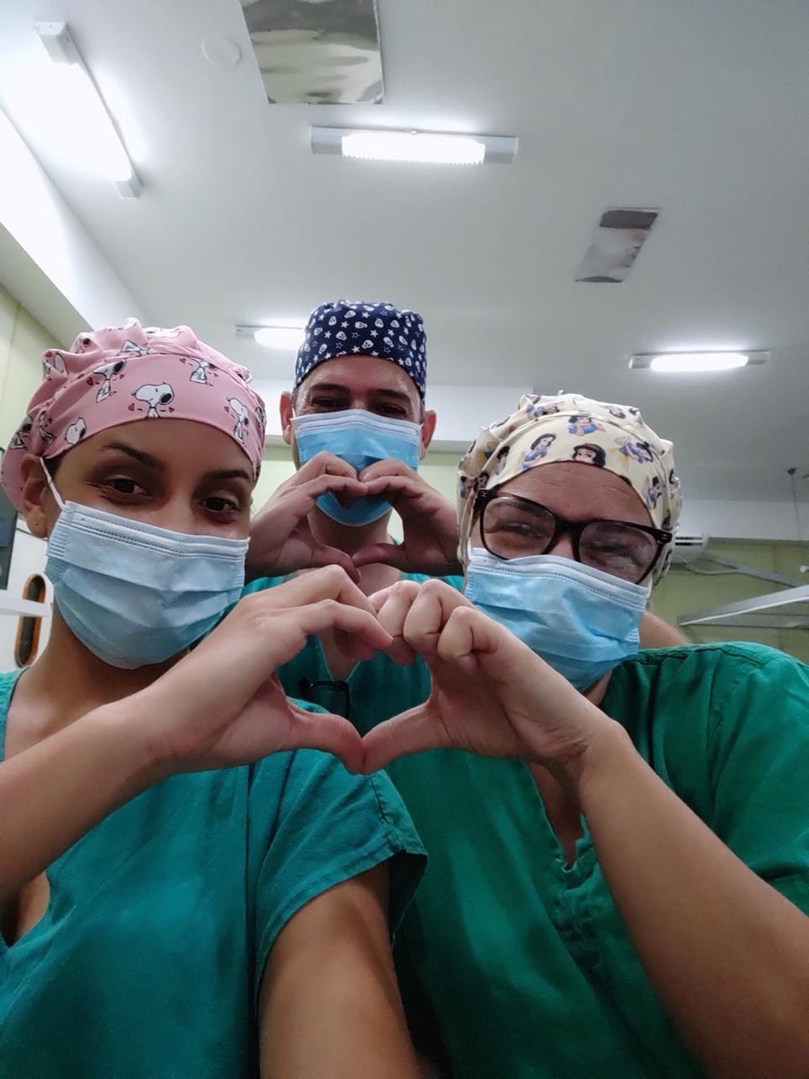 Camila Cardoso e dois colegas de plantão fazendo corações com as mãos